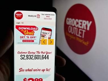 Stuttgart, Almanya - 11-14-2024: ABD 'li perakende şirketi Market Holding Corp' un web sayfası ile akıllı telefon sahibi kişi logo ile ekranda. Telefon ekranının merkezine odaklan.