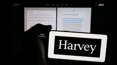 Stuttgart, Almanya - 11-17-2024: Web sayfasının önünde ekranda Amerikan Danışman AI Corporation (Harvey) logosunun bulunduğu cep telefonu sahibi kişi. Telefon ekranına odaklan.