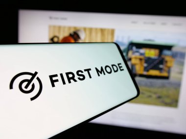 Stuttgart, Almanya - 11-17-2024: Batarya şirketi First Mode Holding Inc. 'nin logosu olan cep telefonu iş sitesinin önünde ekranda. Telefon ekranının merkez soluna odaklan.