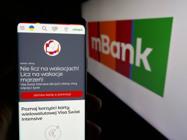 Stuttgart, Almanya - 11-26-2024: Polonyalı bankacılık şirketi mBank S.A. 'nın web sayfası ile akıllı telefon sahibi kişi logonun önünde ekranda. Telefon ekranının merkezine odaklan.