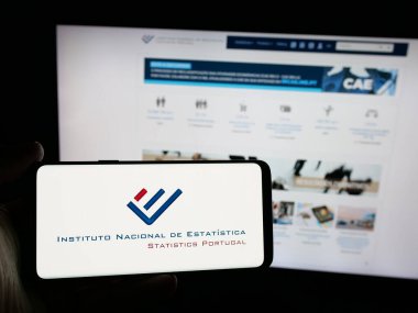 Stuttgart, Almanya - 11-24-2024: İnternet sitesi önünde üzerinde Instituto Nacional de Estatistica Portugal (INE) logosu bulunan kişi. Telefon ekranına odaklan.