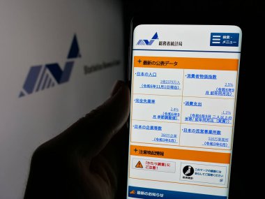 Stuttgart, Almanya - 11-21-2024: Japon İstatistik Bürosu 'nun internet sayfası olan cep telefonu logosu önünde ekranda. Telefon ekranının merkezine odaklan.