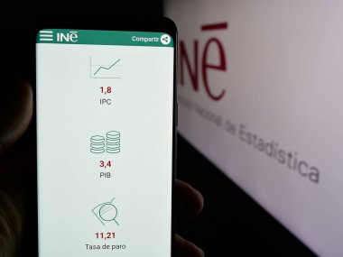 Stuttgart, Almanya - 11-21-2024: İspanyol Enstitüsü 'nün (INE) logolu web sayfası bulunan kişi. Telefon ekranının merkezine odaklan.