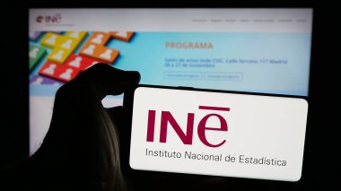 Stuttgart, Almanya - 11-21-2024: İnternet sayfası önünde ekranda İspanyol Enstitüsü logosu bulunan cep telefonu sahibi kişi. Telefon ekranına odaklan.