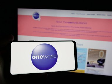 Stuttgart, Almanya - 11-20-2024: Havayolları ittifakı Oneworld logosunun yer aldığı akıllı telefonu web sitesinin önünde tutan kişi. Telefon ekranına odaklan.