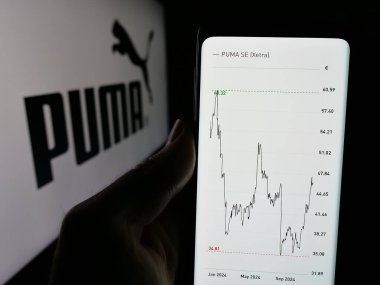 Stuttgart, Almanya - 11-20-2024: Alman ayakkabı ve giyim şirketi Puma SE 'nin web sayfası olan akıllı telefon sahibi kişi logonun önünde ekranda. Telefon ekranının merkezine odaklan.