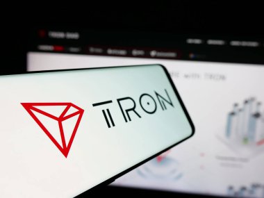 Stuttgart, Almanya - 11-20-2024: Merkezi olmayan TRON logosuna sahip akıllı telefon iş dünyasının web sitesinin önünde ekranda. Telefon ekranının soluna odaklan.
