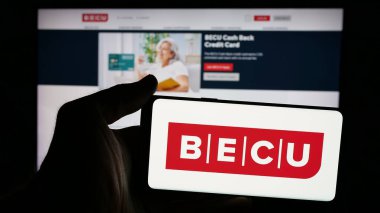 Stuttgart, Almanya - 11-20-2024: Üzerinde ABD kredi birliği BECU logosu bulunan cep telefonu sahibi kişi iş sayfasının önünde ekranda. Telefon ekranına odaklan.