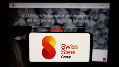 Stuttgart, Almanya - 11-20-2024: Çelik şirketi Swiss Steel Holding AG 'nin logosu olan cep telefonu sahibi kişi iş sayfasının önünde ekranda. Telefon ekranına odaklan.