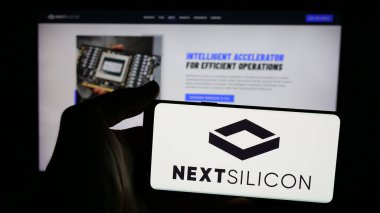 Stuttgart, Germany - 11-18-2024: Person holding mobile phone with logo of Israeli technology company Next Silicon Ltd. on screen in front of web page. Focus on phone display. clipart