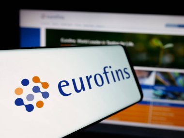 Stuttgart, Almanya - 11-18-2024: Laboratuvar şirketi Eurofins Scientific SE 'nin logosunun yer aldığı cep telefonu iş sitesinin önünde ekranda. Telefon ekranının soluna odaklan.