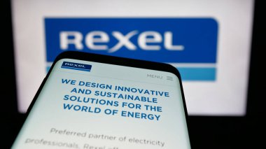 Stuttgart, Almanya - 11-18-2024: Fransız elektrik dağıtım şirketi Rexel S.A. 'nın web sitesiyle birlikte cep telefonu logonun önünde ekranda. Telefon ekranının sol üst kısmına odaklan.