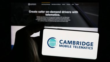 Stuttgart, Almanya - 11-15-2024: Web sayfası önünde ekranda ABD 'li Cambridge Mobile Telematics Inc. (CMT) şirketinin logosuna sahip cep telefonu sahibi kişi. Telefon ekranına odaklan.