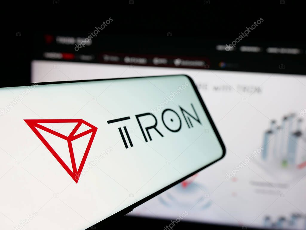 Stuttgart, Germany - 11-20-2024: Smartphone with logo of decentralized blockchain TRON on screen in front of business website. Focus on left of phone display.