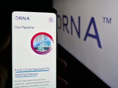 Stuttgart, Almanya - 11-15-2024: ABD 'li biyoteknoloji şirketi Orna Therapeutics Inc.' in web sayfası ile cep telefonu tutan kişi logolu ekranda. Telefon ekranının merkezine odaklan.