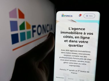 Stuttgart, Almanya - 11-26-2024: Fransız emlak şirketi Foncia SAS 'ın web sayfası olan cep telefonu logosu önünde ekranda. Telefon ekranının merkezine odaklan.