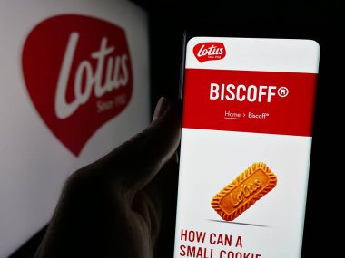 Stuttgart, Almanya - 11-27-2024: Belçikalı abur cubur şirketi Lotus Fırın NV 'nin web sayfası ile akıllı telefon taşıyan kişi logolu ekranda. Telefon ekranının merkezine odaklan.