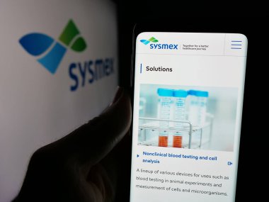 Stuttgart, Almanya - 11-28-2024: Japon sağlık şirketi Sysmex Corporation 'ın internet sayfası ve logosu olan kişi. Telefon ekranının merkezine odaklan.