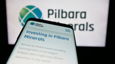 Stuttgart, Germany - 11-28-2024: Mobile phone with website of Australian mining company Pilbara Minerals Limited on screen in front of logo. Focus on top-left of phone display. clipart