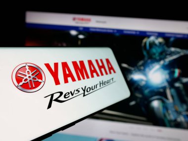 Stuttgart, Almanya - 11-28-2024: Japon otomotiv şirketi Yamaha Motor Co. Ltd. nin logosuna sahip akıllı telefon iş sitesinin önünde ekranda. Telefon ekranının soluna odaklan.