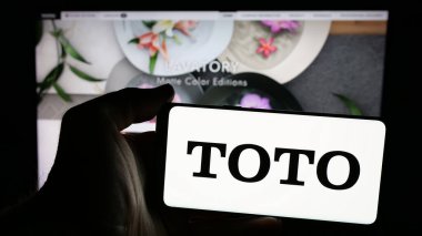 Stuttgart, Almanya - 11-28-2024: Japon tuvalet imalat şirketi Toto Ltd. 'nin logosu olan cep telefonu web sayfasının önünde. Telefon ekranına odaklan.