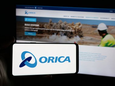 Stuttgart, Almanya - 11-28-2024: Avustralyalı patlayıcı şirketi Orica Limited 'in logosunu elinde tutan kişi web sitesinin önünde ekranda. Telefon ekranına odaklan.