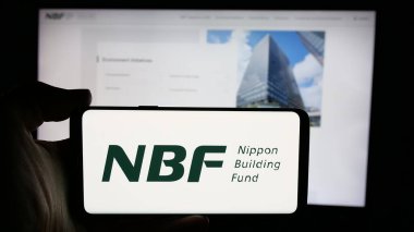 Stuttgart, Almanya - 11-28-2024: Japon firması Nippon Building Fund Inc. (NBF) 'nin logosunun bulunduğu cep telefonu web sayfası önünde. Telefon ekranına odaklan.