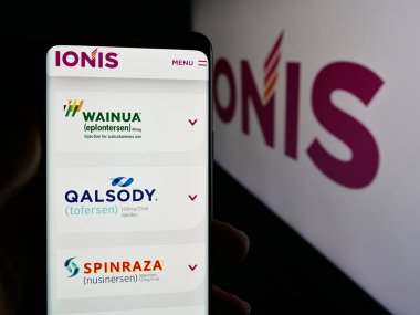 Stuttgart, Almanya - 11-28-2024: ABD 'li biyoteknoloji şirketi Ionis Pharmaceuticals Inc.' in web sayfası ile cep telefonu tutan kişi logo ile ekranda. Telefon ekranının merkezine odaklan.