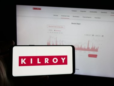 Stuttgart, Almanya - 11-28-2024: ABD 'li emlak şirketi Kilroy Realty Corporation' ın logosunu elinde tutan kişi web sitesinin önünde ekranda. Telefon ekranına odaklan.