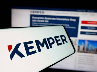 Stuttgart, Almanya - 11-28-2024: Amerikan sigorta şirketi Kemper Corporation 'ın logosu olan cep telefonu iş sitesinin önünde ekranda. Telefon ekranının merkez soluna odaklan.