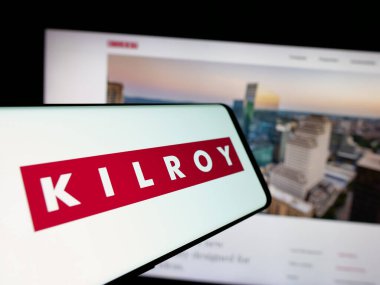 Stuttgart, Almanya - 11-28-2024: ABD 'li emlak şirketi Kilroy Realty Corporation' ın logosunu elinde tutan kişi web sitesinin önünde ekranda. Telefon ekranına odaklan.