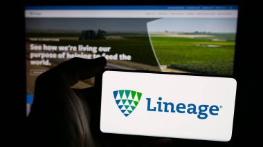 Stuttgart, Almanya - 11-28-2024: Amerikan depolama şirketi Lineage Inc. 'nin logosunun bulunduğu cep telefonu sahibi kişi iş sayfasının önünde ekranda. Telefon ekranına odaklan.