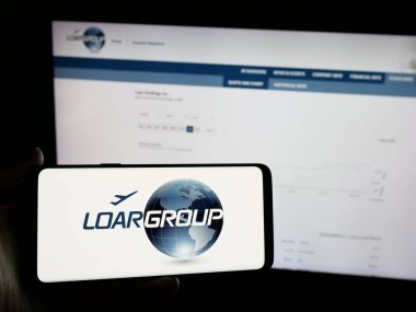 Stuttgart, Almanya - 12-02-2024: ABD 'li üretim şirketi Loar Holding Inc.' nin logosunu elinde tutan kişi web sitesinin önünde ekranda. Telefon ekranına odaklan.