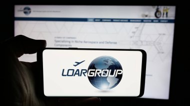 Stuttgart, Almanya - 12-02-2024: ABD 'li imalat şirketi Loar Holding Inc.' nin logosuyla cep telefonu sahibi kişi iş sayfasının önünde ekranda. Telefon ekranına odaklan.