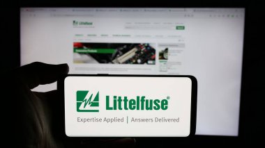 Stuttgart, Almanya - 12-02-2024: ABD 'li elektronik şirketi Littelfuse Inc.' in logosuyla cep telefonu sahibi kişi iş sayfasının önünde ekranda. Telefon ekranına odaklan.
