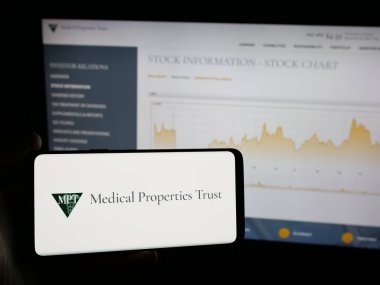 Stuttgart, Almanya - 12-03-2024: ABD 'li emlak şirketi Medical Properties Trust Inc.' in logosuna sahip kişi web sitesinin önünde ekranda. Telefon ekranına odaklan.