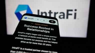 Stuttgart, Almanya - 12-03-2024: ABD 'li finans hizmetleri şirketi IntraFi LLC' nin web sitesiyle birlikte cep telefonu iş logosu önünde ekranda. Telefon ekranının sol üst kısmına odaklan.