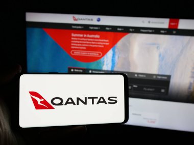 Stuttgart, Almanya - 12-04-2024: Avustralyalı havayolu şirketi Qantas Airways Limited 'in logosuna sahip kişi web sitesinin önünde ekranda görülüyor. Telefon ekranına odaklan.