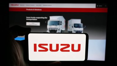 Stuttgart, Almanya - 12-04-2024: Japon otomotiv şirketi Isuzu Motor Ltd. 'nin logosuyla cep telefonu sahibi kişi iş sayfasının önünde ekranda. Telefon ekranına odaklan.