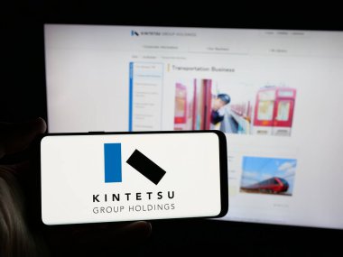 Stuttgart, Almanya - 12-04-2024: Japon şirketi Kintetsu Group Holding Co. Ltd. nin logosuna sahip kişi web sitesinin önünde ekranda. Telefon ekranına odaklan.