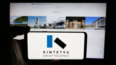 Stuttgart, Almanya - 12-04-2024: Japon şirketi Kintetsu Group Holding Co. Ltd. nin logosuyla cep telefonu sahibi kişi web sayfası önünde ekranda. Telefon ekranına odaklan.