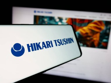 Stuttgart, Almanya - 12-04-2024: Japon şirketi Hikari Tsushin Inc. 'nin logosunun yer aldığı cep telefonu iş sitesinin önünde ekranda. Telefon ekranının soluna odaklan.