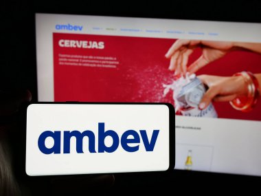 Stuttgart, Almanya - 12-04-2024: Brezilyalı meşrubat şirketi Ambev S.A. 'nın logosunu taşıyan kişi web sitesinin önünde ekranda. Telefon ekranına odaklan.
