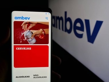 Stuttgart, Almanya - 12-04-2024: Brezilyalı meşrubat şirketi Ambev S.A. 'nın web sayfasını elinde tutan kişi logonun önünde ekranda. Telefon ekranının merkezine odaklan.