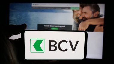 Stuttgart, Almanya - 12-04-2024: İsviçreli Bank Cantonale Vaudoise (BCV) şirketinin logosunun bulunduğu cep telefonu sahibi kişi iş sayfası önünde ekranda. Telefon ekranına odaklan.