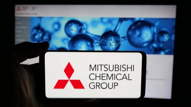 Stuttgart, Almanya - 12-05-2024: Mitsubishi Chemical Group Corporation şirketinin logosuyla cep telefonu sahibi kişi iş sayfası önünde ekranda. Telefon ekranına odaklan.