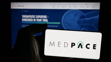 Stuttgart, Almanya - 12-05-2024: Web sayfası önünde ekranda ABD 'li klinik araştırma şirketi Medpace Holding Inc.' nin logosunun bulunduğu cep telefonu sahibi kişi. Telefon ekranına odaklan.