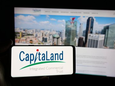Stuttgart, Almanya - 12-05-2024: CapitaLand Integrated Commercial Trust (CICT) logosunun bulunduğu akıllı telefonu web sitesi önünde tutan kişi. Telefon ekranına odaklan.