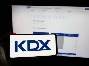 Stuttgart, Almanya - 12-05-2024: Japon şirketi KDX Realty Investment Corporation 'ın logosunu elinde tutan kişi web sitesinin önünde ekranda. Telefon ekranına odaklan.