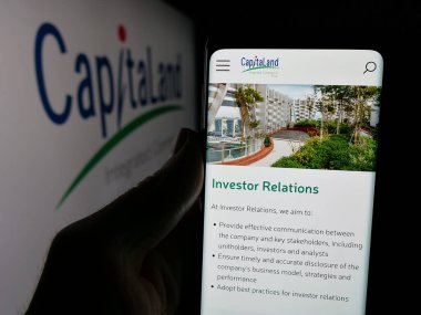 Stuttgart, Almanya - 12-05-2024: KapitaLand Integrated Commercial Trust 'ın (CICT) web sayfası logo önünde bulunan kişi. Telefon ekranının merkezine odaklan.